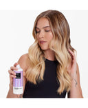 a woman holding a spray bottle