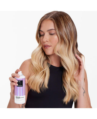 a woman holding a spray bottle