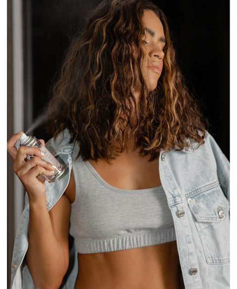 a woman with long hair holding a can of spray