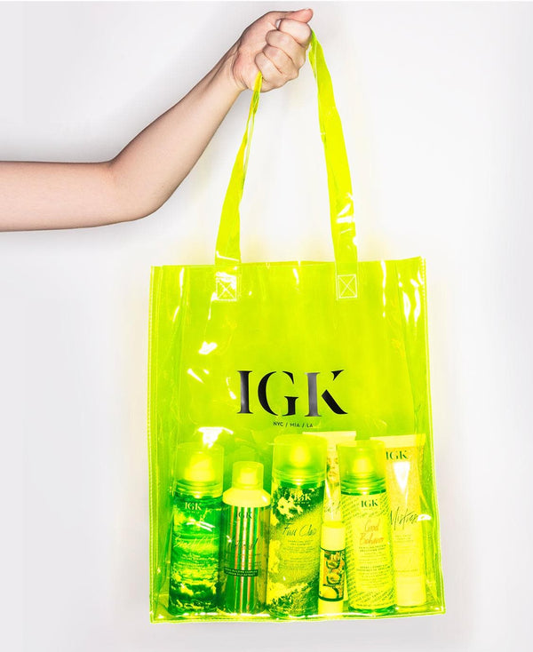a hand holding a yellow bag with bottles inside