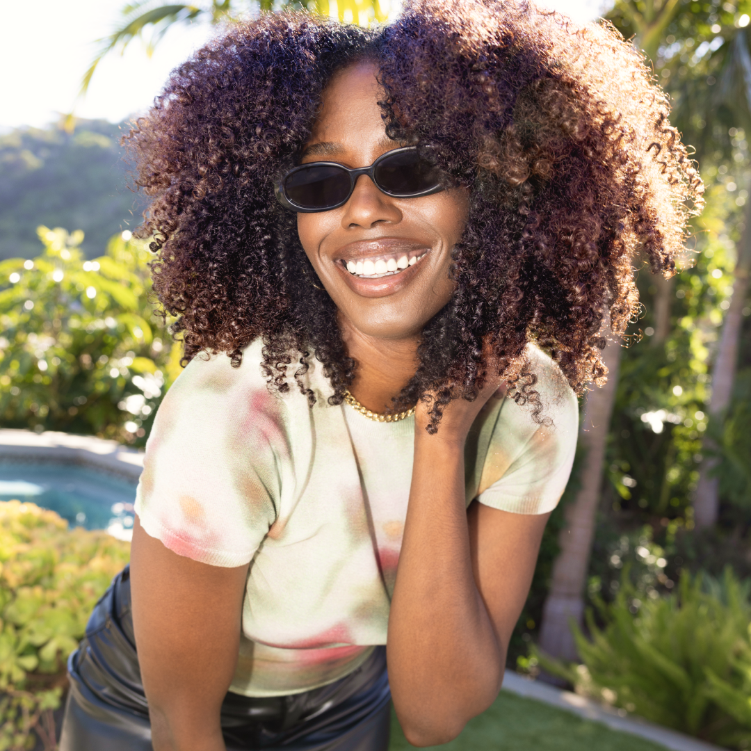 a woman wearing sunglasses and smiling