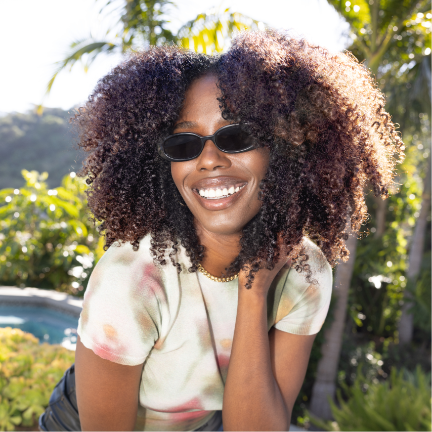 a woman wearing sunglasses and smiling